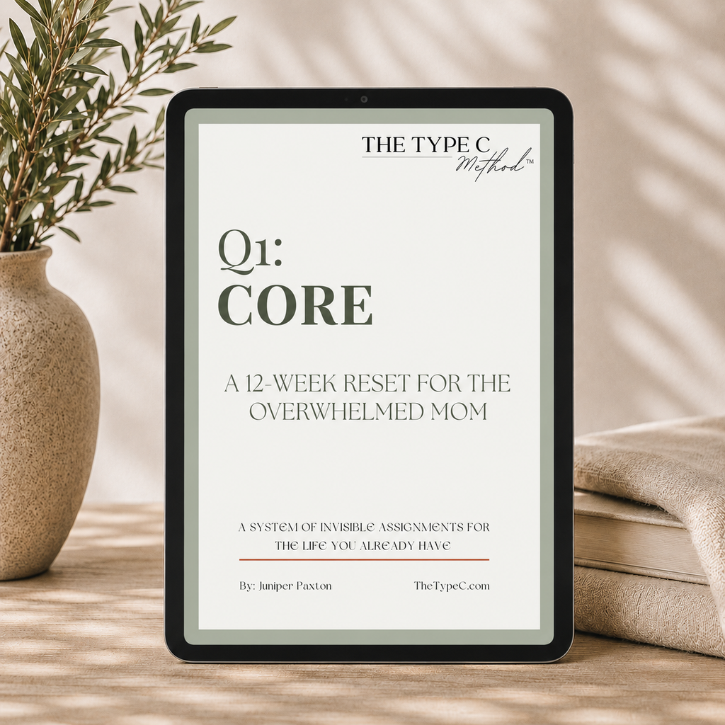 An editorial, quiet luxury mockup of a digital tablet with a sage green border displaying the cover of The Type C Method, Volume 1: CORE workbook. The text on screen reads 'A 12-Week Reset for the Overwhelmed Mom.' The tablet rests on a warm cream surface in a minimalist setting, styled with a textured ceramic vase, green branches, folded linen, and elegant dappled sunlight shadows.